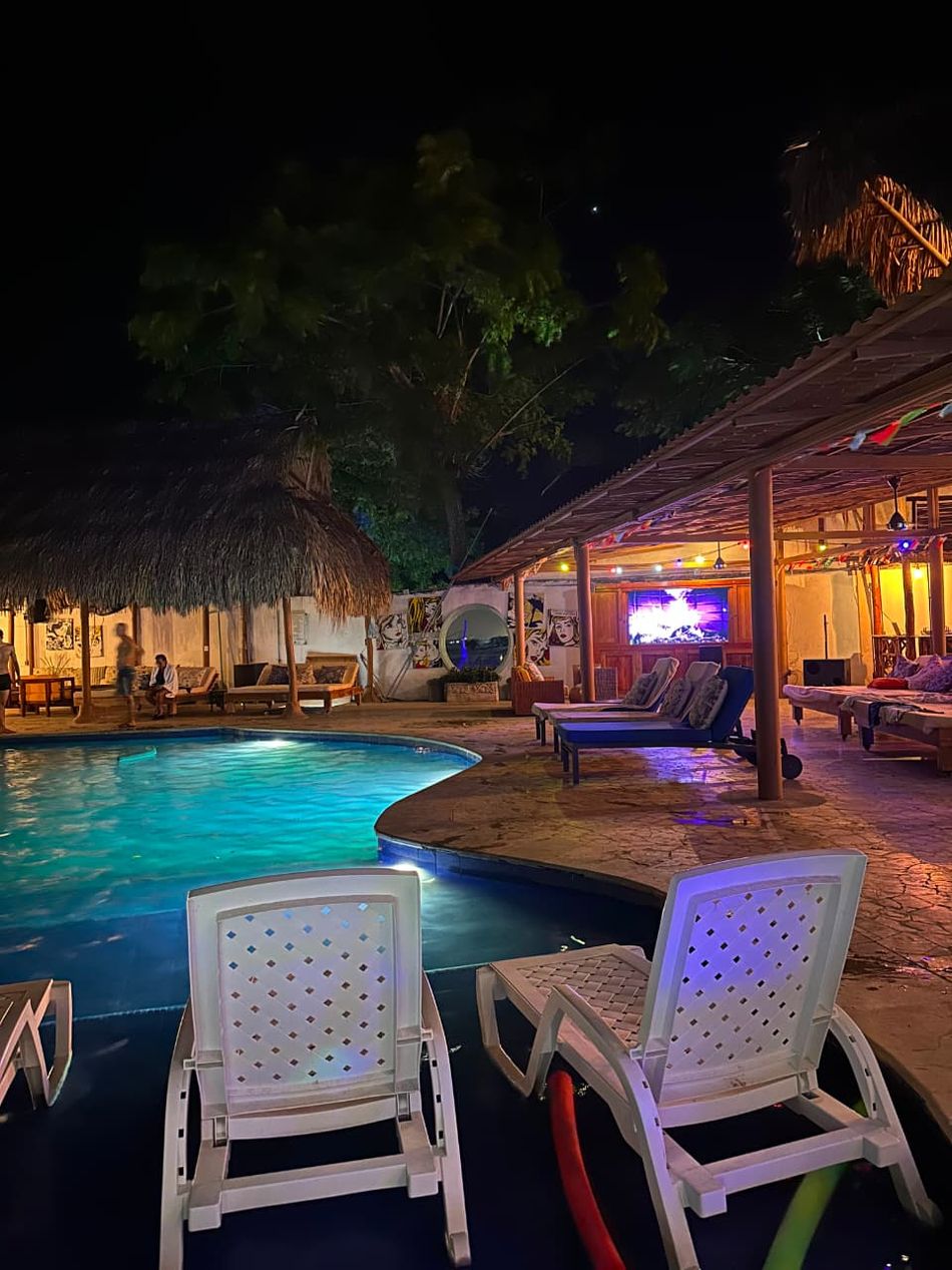 Piscina y zona de descanso iluminadas de noche